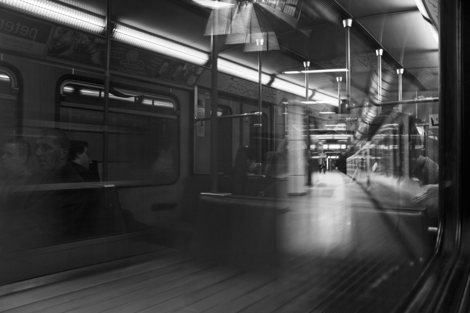 Black-and-white photograph of reflections inside a metro train
